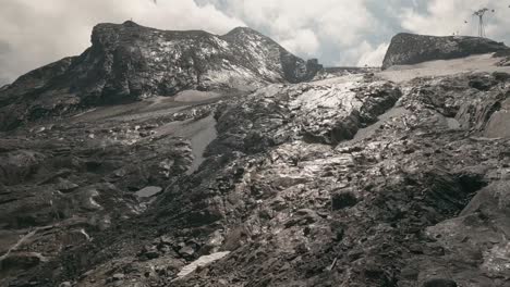 FPV-drone-explores-Kaprun's-Kitschteinhorn-glacier,-revealing-melting-ice,-wet-rocks,-and-gushing-streams,-a-visual-of-global-warming