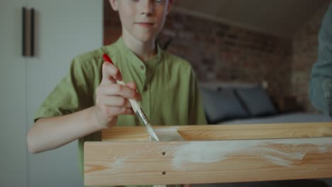 boy painting wooden furniture