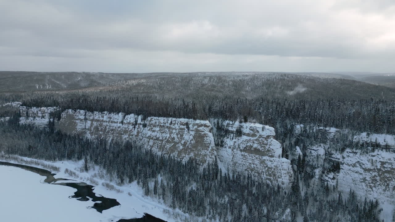 paisaje invernal nevado con río y acantilado