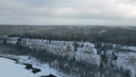 paisaje invernal nevado con río y acantilado