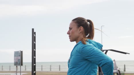 Sporty-Caucasian-woman-exercising-in-an-outdoor-gym-during-daytime