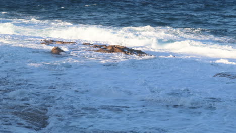 4k waves hitting rocks in the shallows in malta