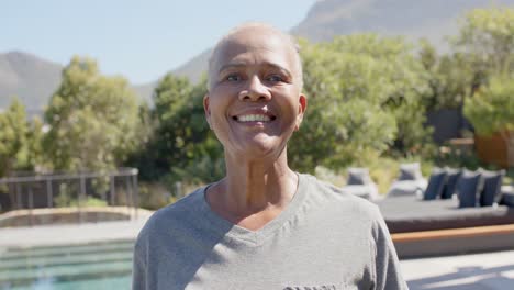 Portrait-of-happy-senior-african-american-woman-in-sunny-garden,-unaltered,-in-slow-motion