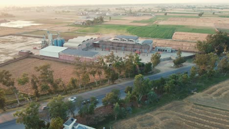 Drone-view-of-a-rice-mill-and-agricultural-field-in-Pakistan,-village-life-in-Pakistan