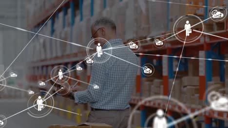 Animation-of-network-of-digital-icons-over-caucasian-male-supervisor-checking-stock-at-warehouse