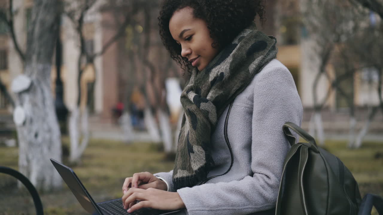 Young Woman Working on Laptop in Park