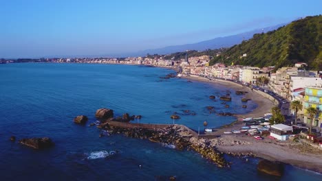 a drone flies along the coast of catania accross the bright blue mediterranean sea