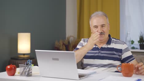 home office worker old man makes heart symbol looking at camera.