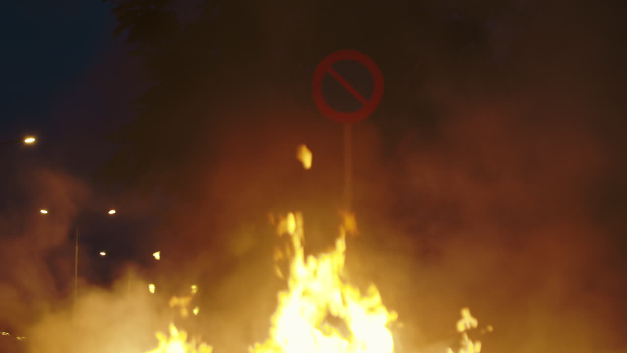 Large Fire and Smoke at Night with Obscured Road Sign
