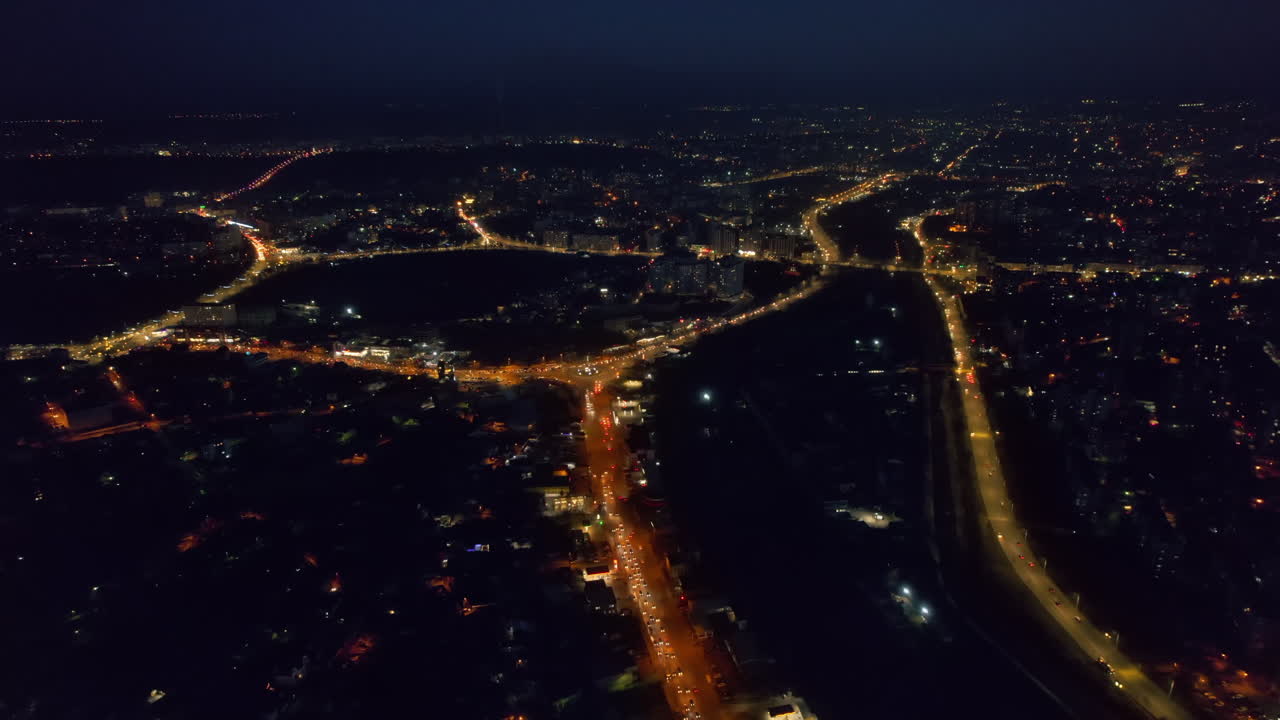 Aerial drone view of Chisinau at sunset, Moldova. View of the city with multiple buildings, roads with traffic, illumination