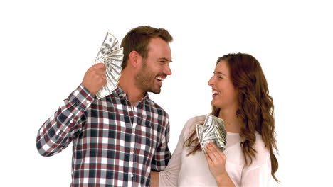 una pareja feliz agitando dinero.