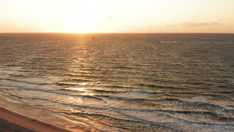 kitesurfers near the beach of domburg during sunset