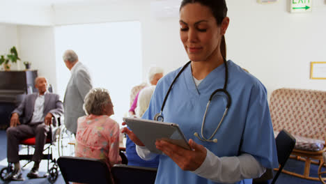 vista frontal de una doctora caucásica usando una tableta digital en un hogar de ancianos 4k