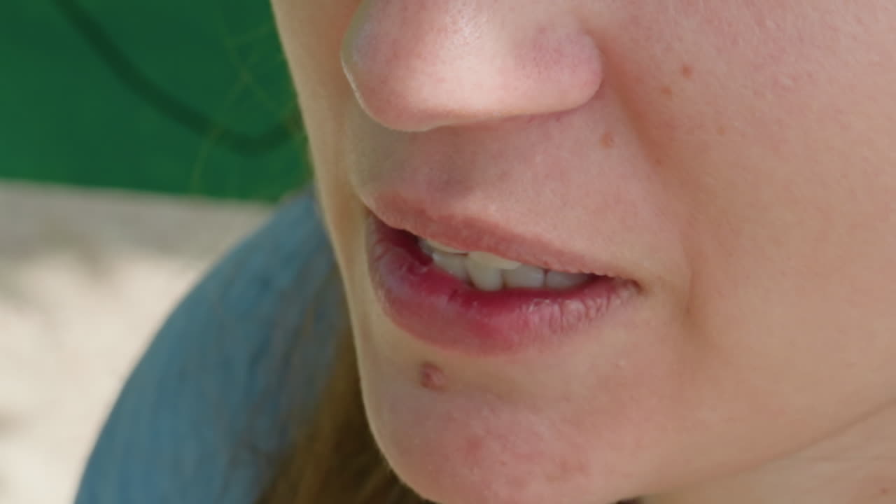 Крупный план улыбающейся кавказской женщины на улице; радостная женщина наслаждается солнечным светом; случайный снимок, на котором запечатлена игривая кавказская женщина с жизнерадостным выражением лица на улице в солнечный день