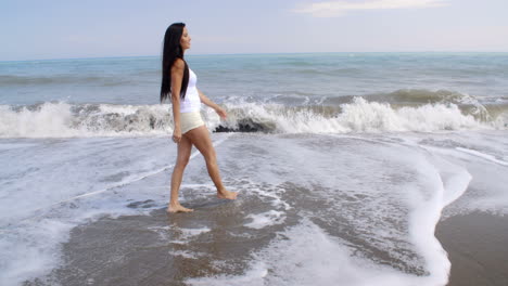 Woman-Walking-Along-Shore-of-Tropical-Beach