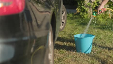 Llenando-Un-Balde-De-Agua-Con-Una-Manguera-De-Jardín-Antes,-Proceso-De-Lavado-De-Autos