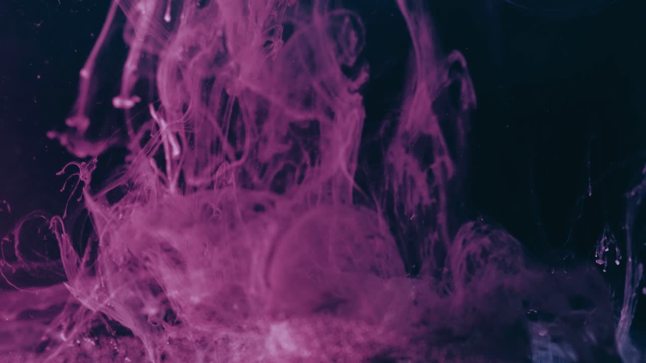 Purple paint flowing down slowly in water, black background