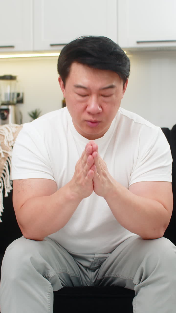 Asian man throws bills aside then calms mind picks papers and follows plan with steady clear resolve