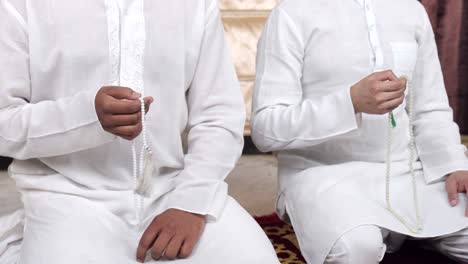 indian muslim men praying beads and praying to allah