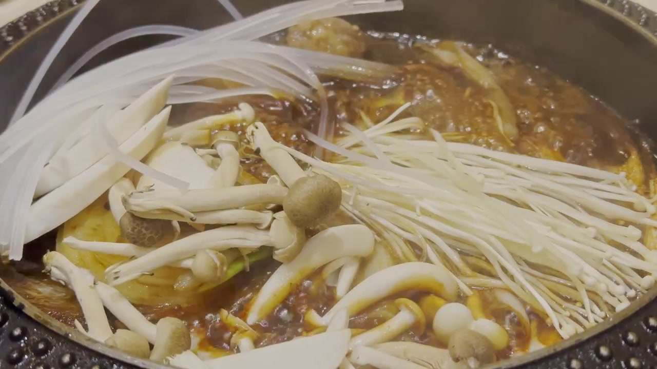 Video ravvicinato di brodo nero di sukiyaki giapponese che bolle vigorosamente in un hot pot. Zuppa fumante che sobbolle in una pentola tradizionale, mostrando l'autentica cucina giapponese hot pot e un'atmosfera calda e accogliente.
