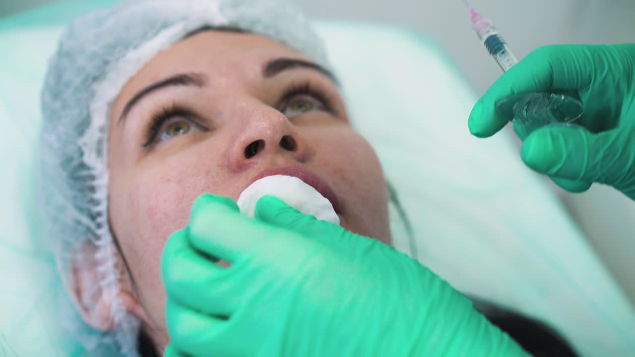 especialista hace inyección para el aumento de los labios a la mujer