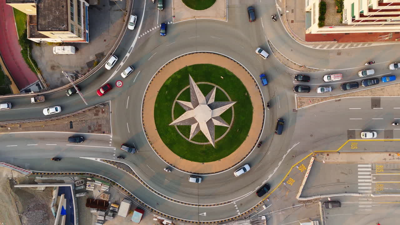 Drone top-down view of cars moving around modern Wind Rose Roundabout in Genoa, Italy in daylight
