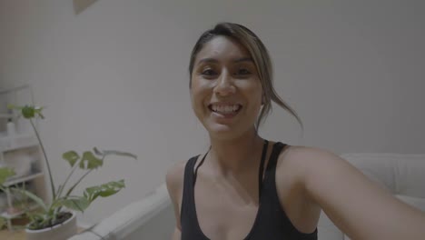 una mujer hispana despidiéndose de sus amigos a través de su dispositivo en línea