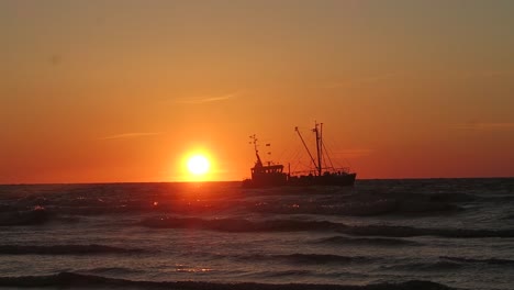 a fishermans boat on the nordsea with the sunsetting