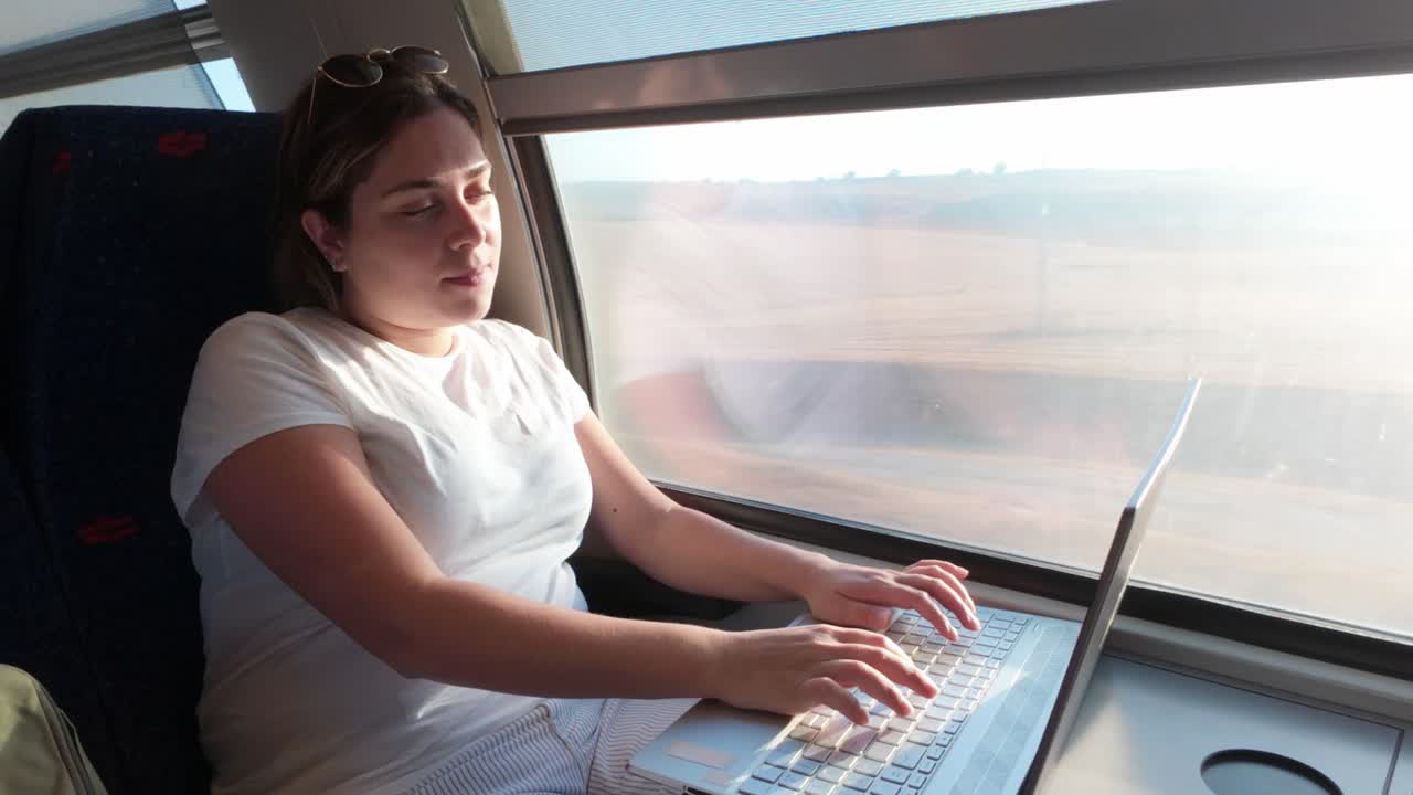 Donna pensierosa che riflette mentre lavora al portatile su un treno