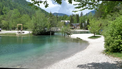walking shot of lake jasna in slovenia with small wooden bridge.  4k 50 fps shot