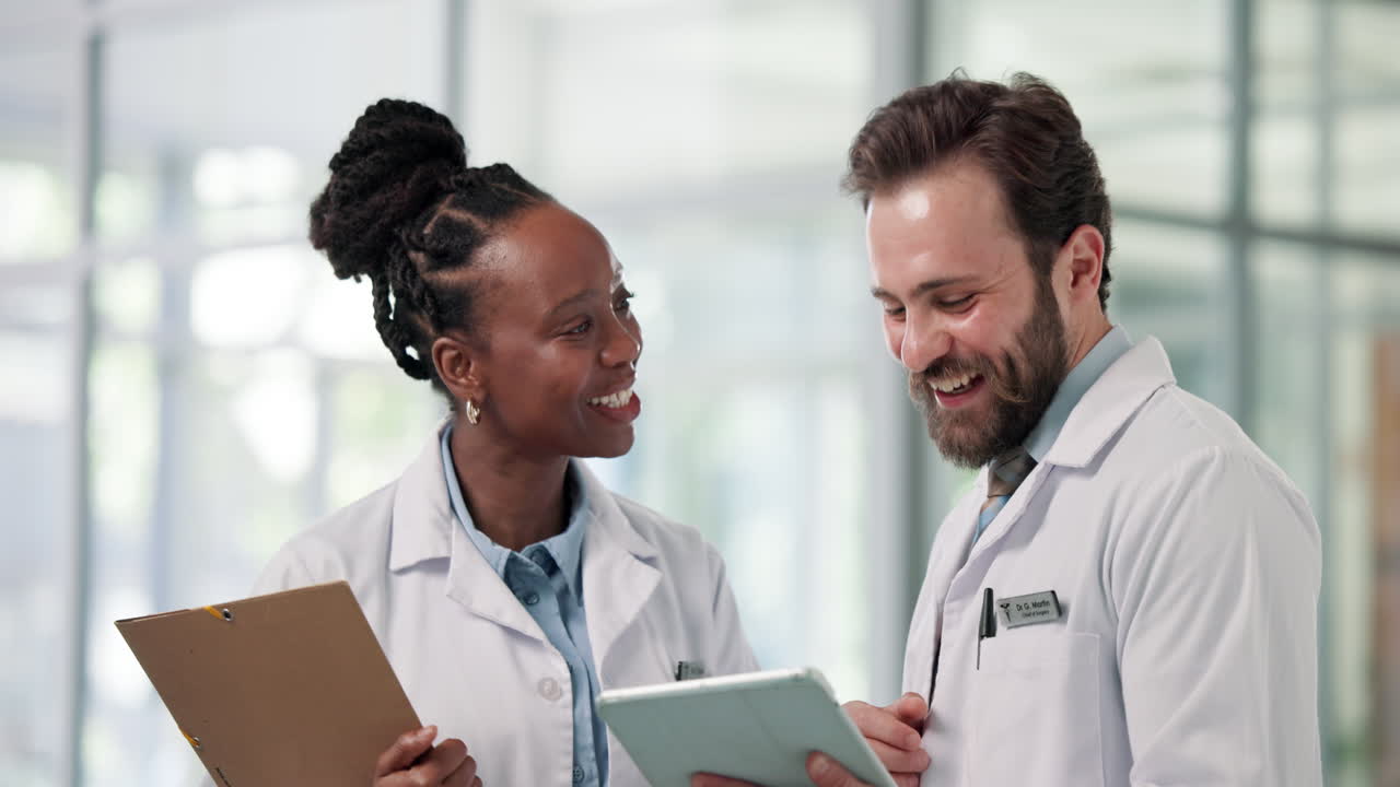 Two Diverse Doctors Collaborating and Smiling with a Digital Tablet