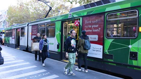 people boarding and exiting a tram in melbourne