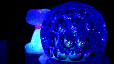 a spinning glass blue disco ball on the dark room.