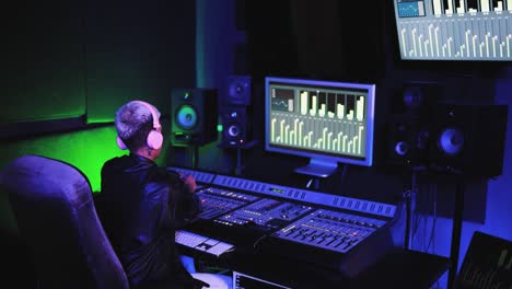 musician and sound female engineer mixing new album inside boutique recording studio - technology and music industry concept