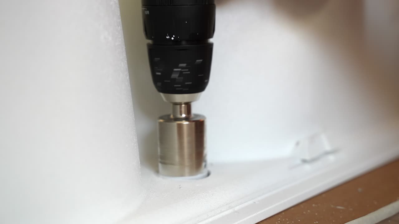 다이아몬드 크라운을 가진 굴착 도구를 사용하여 백색 세라 타일의 재구성, 회전 및 구을 만들기, 다이아먼드 코어 비트 회전, 철거 세라 재료 및  세라 먼지를 주변에 뿌리는 건설 현장에서 사용되는 굴착 장비