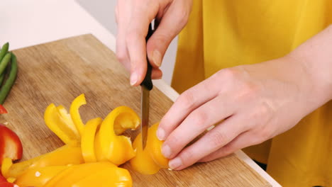 primer plano de una mujer cortando verduras