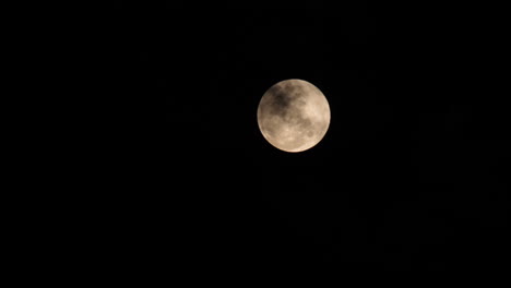 full moon in a dark night with black clouds, closeup