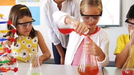 niños de la escuela haciendo un experimento químico en el laboratorio
