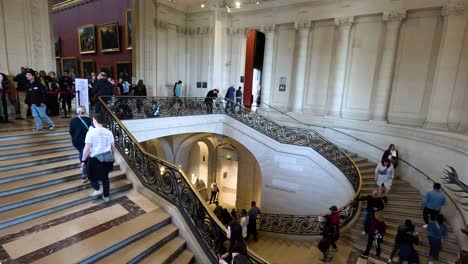 people ascending and descending a large ornate staircase