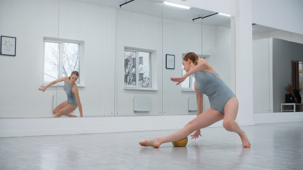 Female Dancer Stretching with Yoga Ball
