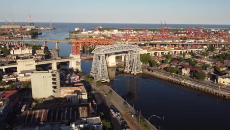 aerial flight towards port of buenos aires with river and traffic on bridge at sunset time