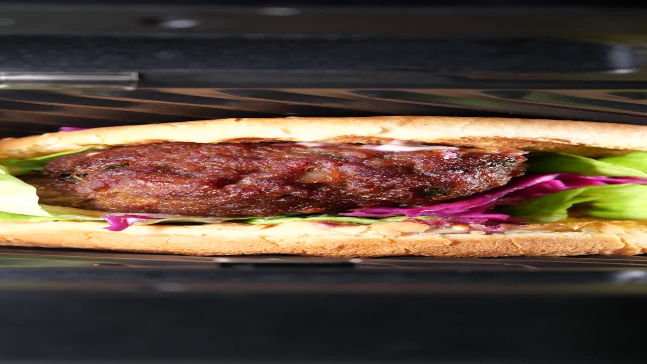 primer plano de una hamburguesa jugosa con lechuga y repollo rojo