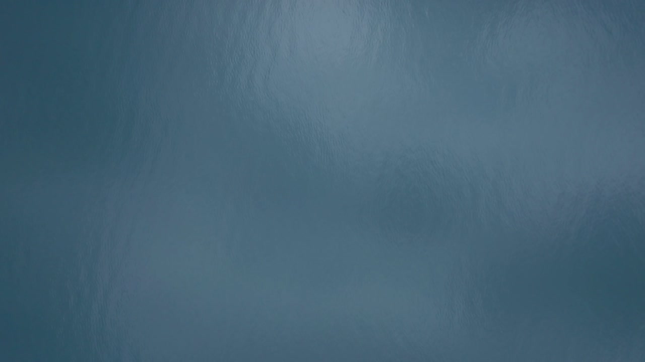 Dron letící nad klidným jezerem.