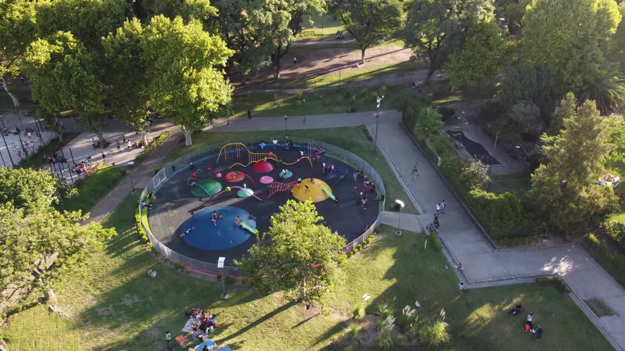 niños disfrutando de columpios y toboganes en el parque centenario de buenos aires, argentina