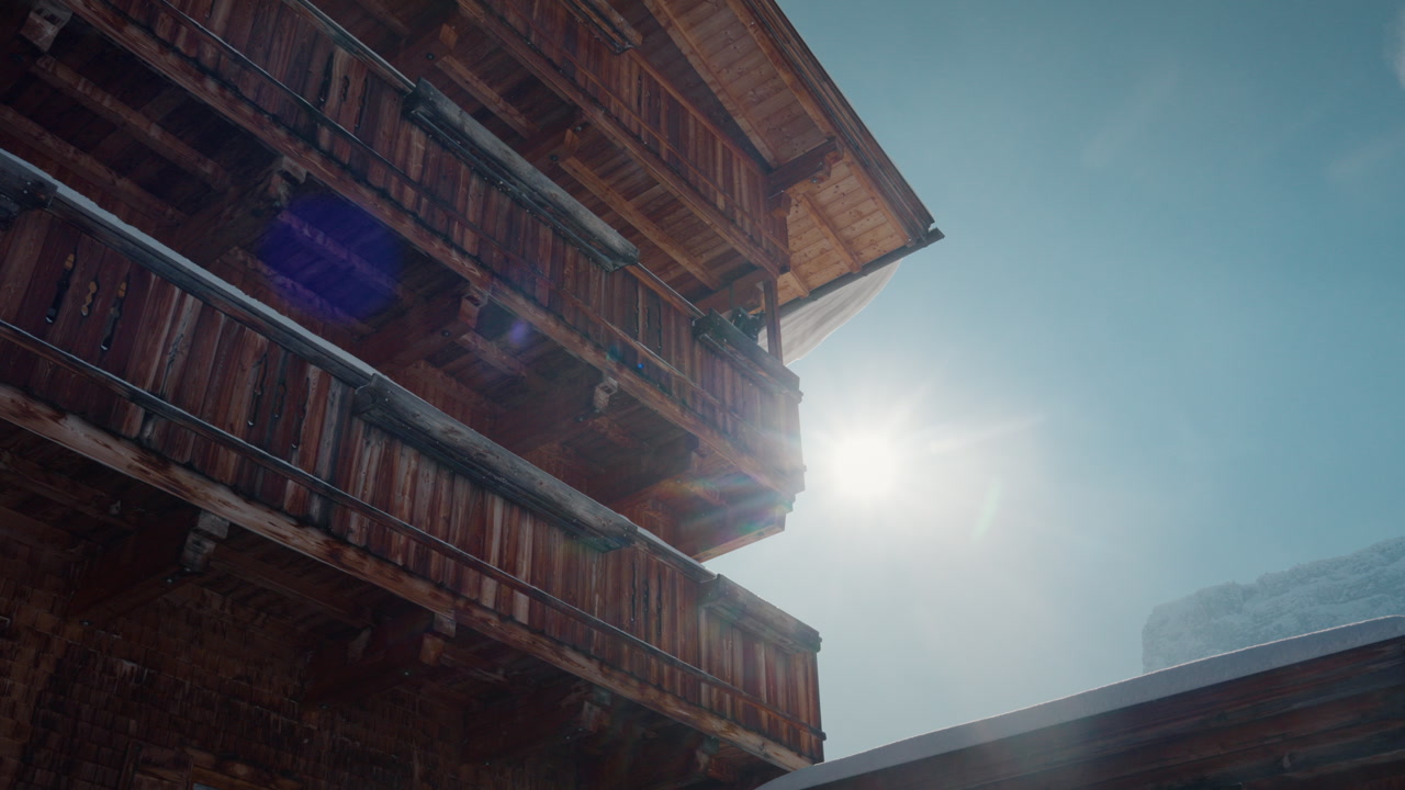 Sunlit wooden chalet against clear sky in Zillertal. Perfect for travel or winter promotional content.