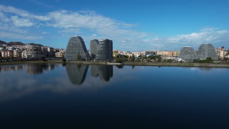 Lakeside-Reflections:-Tirana's-Buildings-Mirror-in-the-Calm-Waters-of-the-Artificial-Lake,-Enhancing-the-City's-Tranquil-Beauty