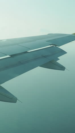 view from a plane window of the sky with the wing of the plane in shot in vertical