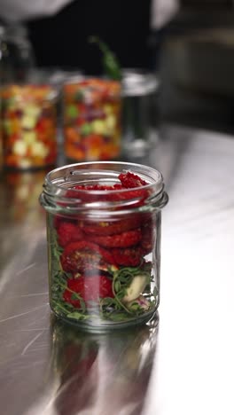 dried tomatoes in a jar with herbs