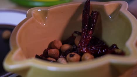 el cocinero prepara pimientos rojos y nueces en un tazón tradicional