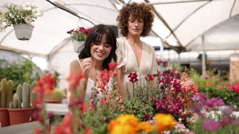 women enjoying flower scents in greenhouse